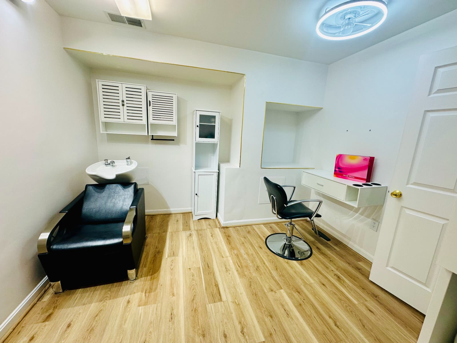 Finished salon suite with shampoo station, mirror, shelving, and styling chair